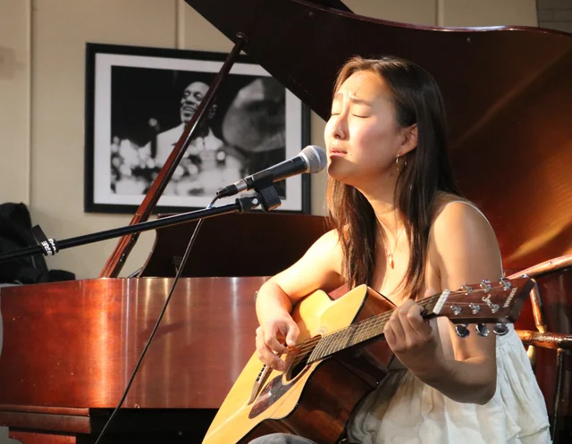 Jin-Hee Lee playing guitar at Stanford CoHo